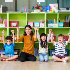 teacher and kids raising their hands